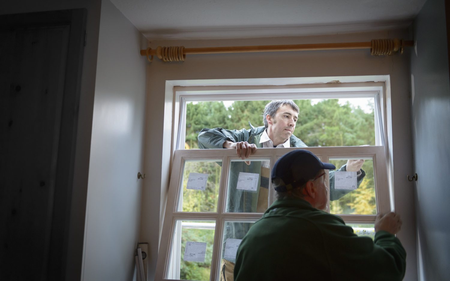 Installation team fitting a new replacement window into a home